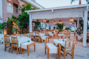 a dining area with white tables and chairs at Kassandra Boutique Hotel in Oludeniz