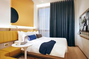 a hotel room with a bed and a laptop on a table at Citadines Connect City Centre Singapore in Singapore