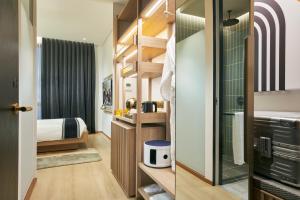 a small room with a bed and a bathroom at Citadines Connect City Centre Singapore in Singapore