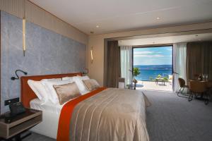 a hotel room with a bed and a view of the ocean at Hotel Medistone in Omiš