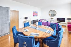 ein Wohnzimmer mit einem Holztisch und blauen Stühlen in der Unterkunft Host & Stay - Chilton at Carlill House in Whitby