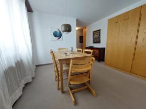 a dining room table and chairs in a room at Arosa Brueggli B02 in Arosa