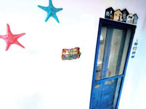 Una pared con una puerta azul y estrellas. en Trullo Don Gabriel, en Alliste