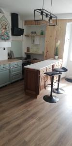 uma cozinha com uma mesa e dois bancos em La Marselloise 105 m² em Marsilly