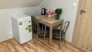 einen kleinen Tisch und Stühle neben einem kleinen Kühlschrank in der Unterkunft Bar&Noclegi Grey in Włodawa