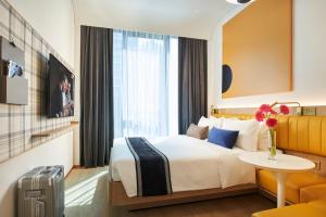 a hotel room with a bed and a table at Citadines Connect City Centre Singapore in Singapore