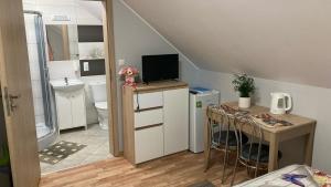 a small kitchen with a small table and a bathroom at Pokoje Grey in Okuninka