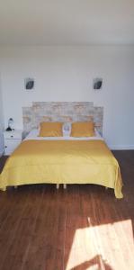 a bedroom with a bed with a yellow bedspread at La Marselloise 105 m² in Marsilly
