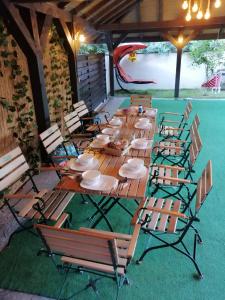 a group of wooden tables and chairs on a patio at Casa Dor de Lac in Salcioara +53 photos