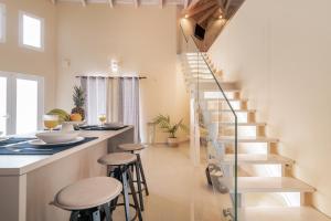 a staircase in a kitchen with stools next to a counter at Chryssi Akti Family Villa and Studios in Argassi