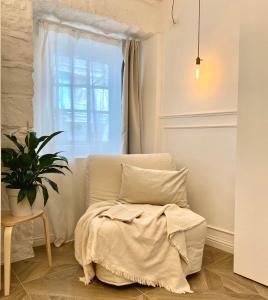 ein Schlafzimmer mit einem Bett und ein Fenster mit einer Pflanze in der Unterkunft L ESSENZIALE a Trieste in Triest