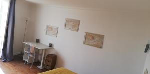 a room with a white wall with three pictures on it at La Marselloise 105 m² in Marsilly
