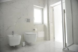 サレルノにあるParadise Luxury Apartment Salerno Centerの白いバスルーム(トイレ、窓付)