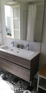 a bathroom with a sink and a mirror at La Marselloise 105 m² in Marsilly