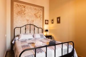 una camera da letto con un letto con un grande quadro appeso alla parete di Casa Palma 12 a Vilafranca del Penedès