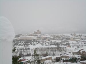 una ciudad cubierta de nieve con una ciudad en el fondo en Cueva de La Alegría, en Huéscar