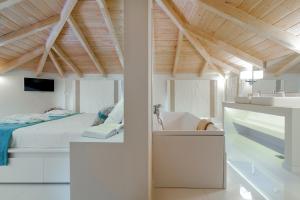a white bedroom with a bed and a sink at Chryssi Akti Family Villa and Studios in Argassi