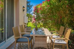 a table and chairs on a patio with flowers at Chryssi Akti Family Villa and Studios in Argassi