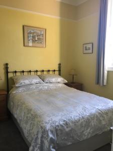 ein Schlafzimmer mit einem großen Bett mit einer weißen Bettdecke in der Unterkunft The Oaks in Swaffham