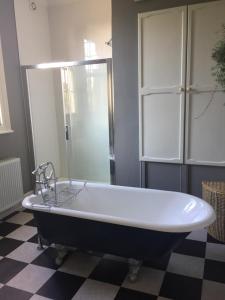 a bath tub in a bathroom with a checkered floor at The Oaks in Swaffham