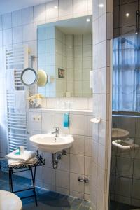 y baño con lavabo y espejo. en Hotel Vier Jahreszeiten, en Volkach