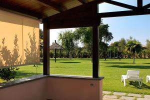 a view of a park from a large window at Agriturismo Bocci in Castiglione della Pescaia