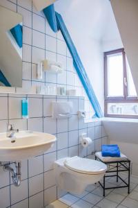 ein Bad mit einem Waschbecken und einem WC in der Unterkunft Hotel Vier Jahreszeiten in Volkach