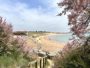 a beach with people on the sand and the water at Appartement 2 pièces, 3 couchages, piscine chauffée, proche plage et commerces à Bretignolles-sur-Mer - FR-1-224A-45 in Brétignolles-sur-Mer