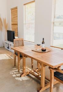 a wooden dining room table with two chairs and a television at S T U D I O 22 Peaceful Retreat with Garden Views in Port Lincoln