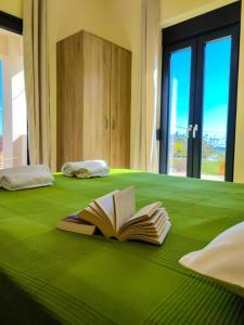 an open book laying on a green bed at Villa Alexander 2 in Triopetra