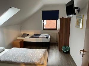 a small bedroom with two beds and a window at Bed4You Gästehaus 1 in Bergshausen