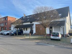 a white house with cars parked in front of it at Bed4You Gästehaus 1 in Bergshausen