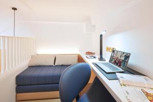 a room with a desk with a laptop and a couch at Citadines Connect City Centre Singapore in Singapore