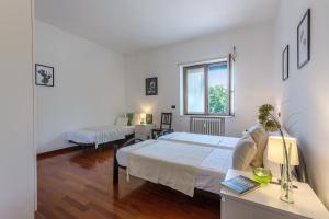 a white bedroom with a bed and a window at Prospettiva Corso Giovecca apartment in Ferrara