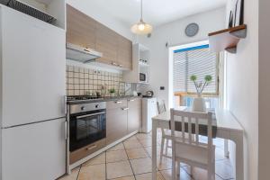 a kitchen with a table and a dining room at Prospettiva Corso Giovecca apartment in Ferrara
