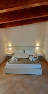 uma cama branca num quarto com duas mesas em B&B Borgo Degli Ulivi em Vieste