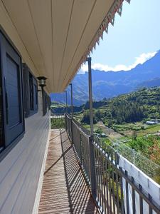 a balcony of a house with a view of the mountains at Petite fleur de lentilles in Cilaos