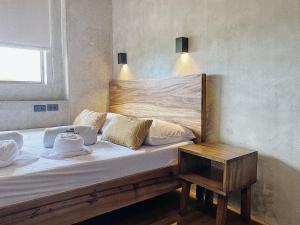 un letto con testiera in legno e tavolo di Shorebreak Hostel San Juan La Union a san juan la union