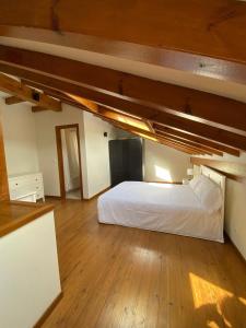a bedroom with a white bed in a room with wooden floors at Chalet Cobijón 10B 
