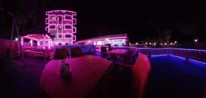 a lit up building with purple lights at night at 300M FROM BEACH GLORIAS HOTEL BEACH VIEW in Mandarmoni