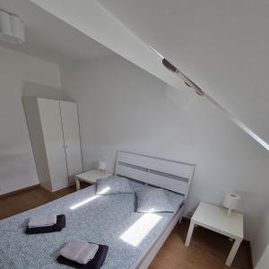 una camera bianca con un letto con due asciugamani di Beautiful Modern Apartment a Bruxelles
