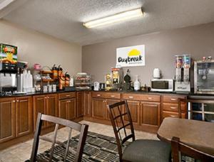 a kitchen with wooden cabinets and a table and chairs at Days Inn by Wyndham Cloverdale Greencastle in Cloverdale