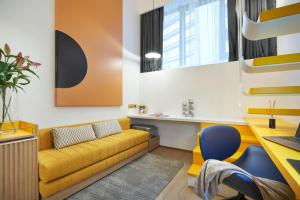 a living room with a yellow couch and a desk at Citadines Connect City Centre Singapore in Singapore