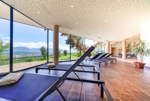 a row of exercise benches in a room with large windows at DAS MATSCHER Residence & Garden Hotel in Appiano sulla Strada del Vino