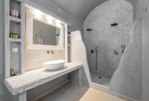 a bathroom with a sink and a shower at Anatoli Hotel & Spa in Fira