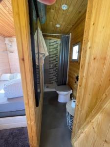 a bathroom with a toilet in a wooden cabin at La Maison du Bonheur Roulotte in Saint-Ouen-sous-Bailly