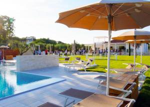 a group of chairs and an umbrella next to a pool at Aldero Hotel in Civita Castellana