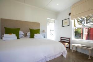 a bedroom with a large white bed with green pillows at Springvale Farm in Nottingham Road