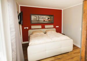 a bedroom with a white bed and a red wall at Nachtigall in Krakow am See