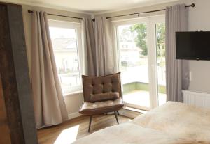 a bedroom with a chair and a bed and a window at Nachtigall in Krakow am See